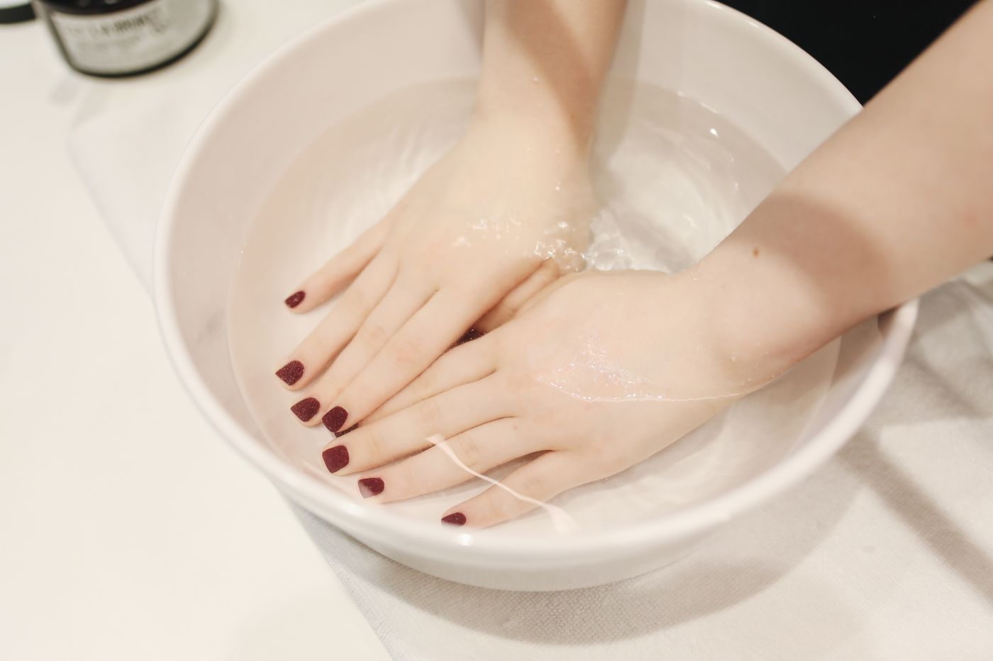 客人把手浸在白瓷碗的温水里